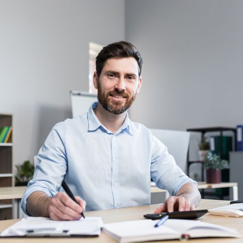 Portrait of a young man smiling sitting at a desk